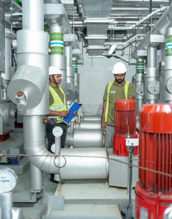 men in a factory with many pipes